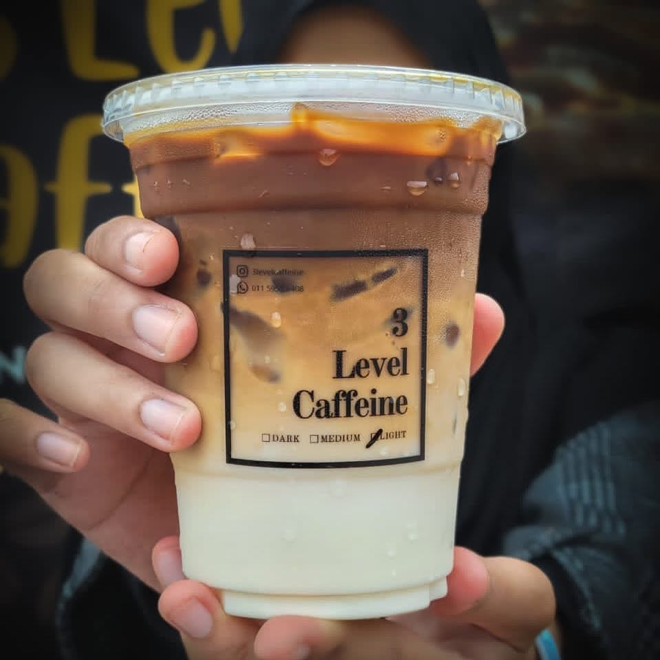 Hand holding a cup showing the three levels
